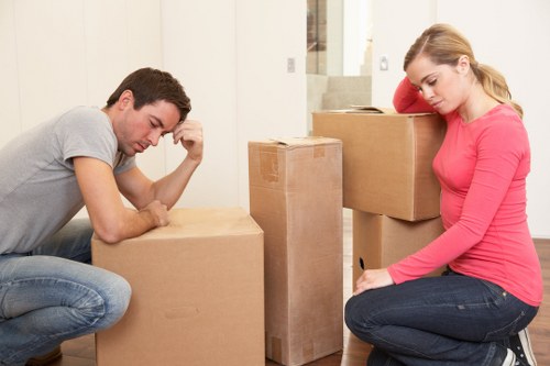 Professional movers carrying furniture down stairs in a flat
